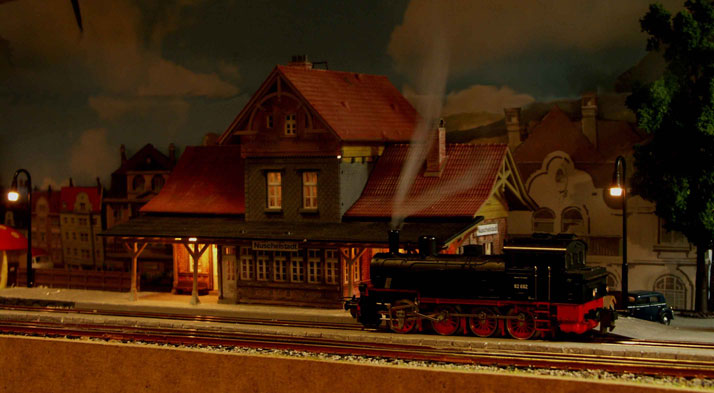 Bild: Nachtansicht vom Bahnhofsgebude Nuschelstadt mit pausierender BR92 und eingeschaltetem Damfgenerator.